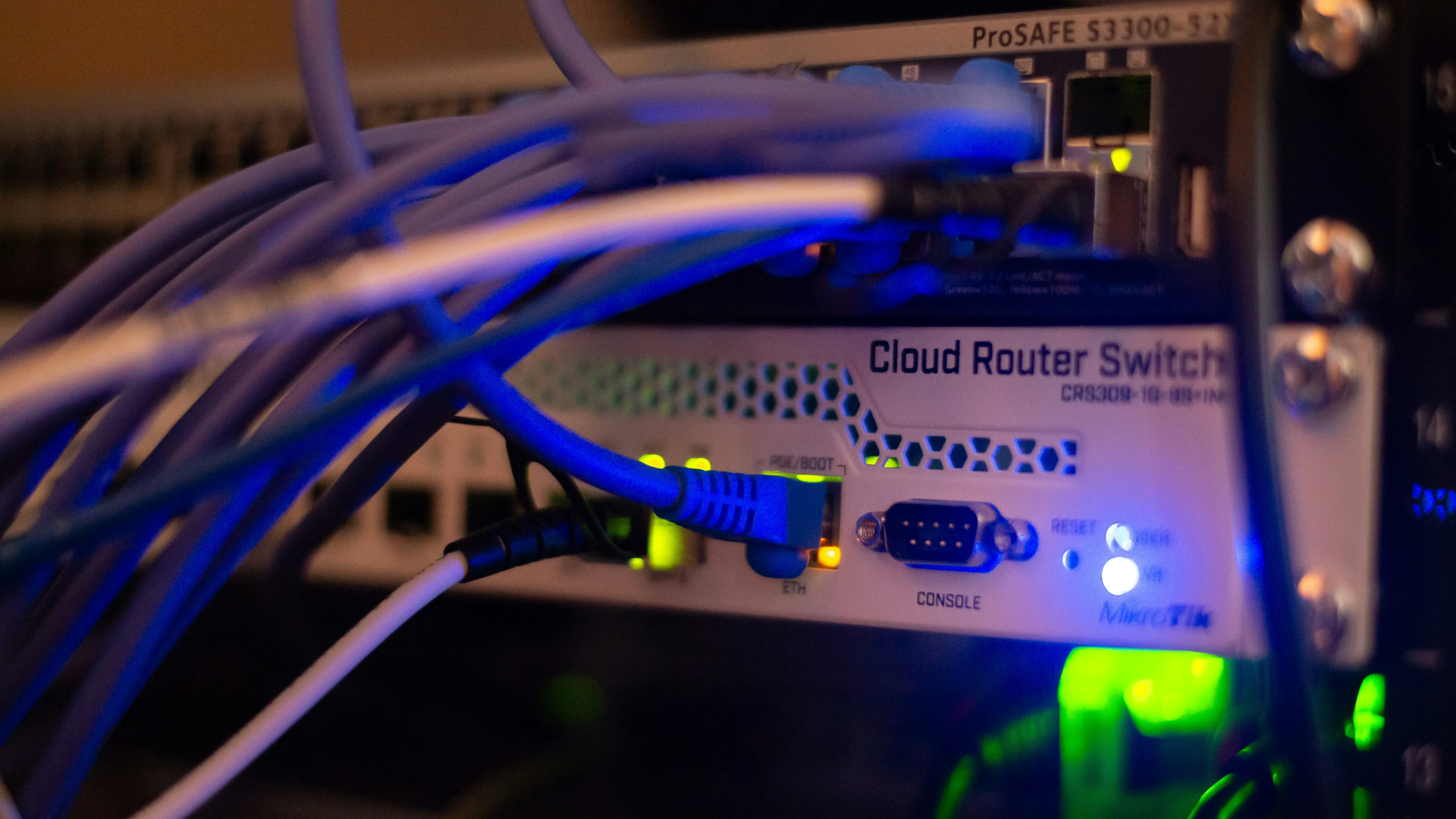 Switch de red empresarial con cables azules conectados en panel de distribución