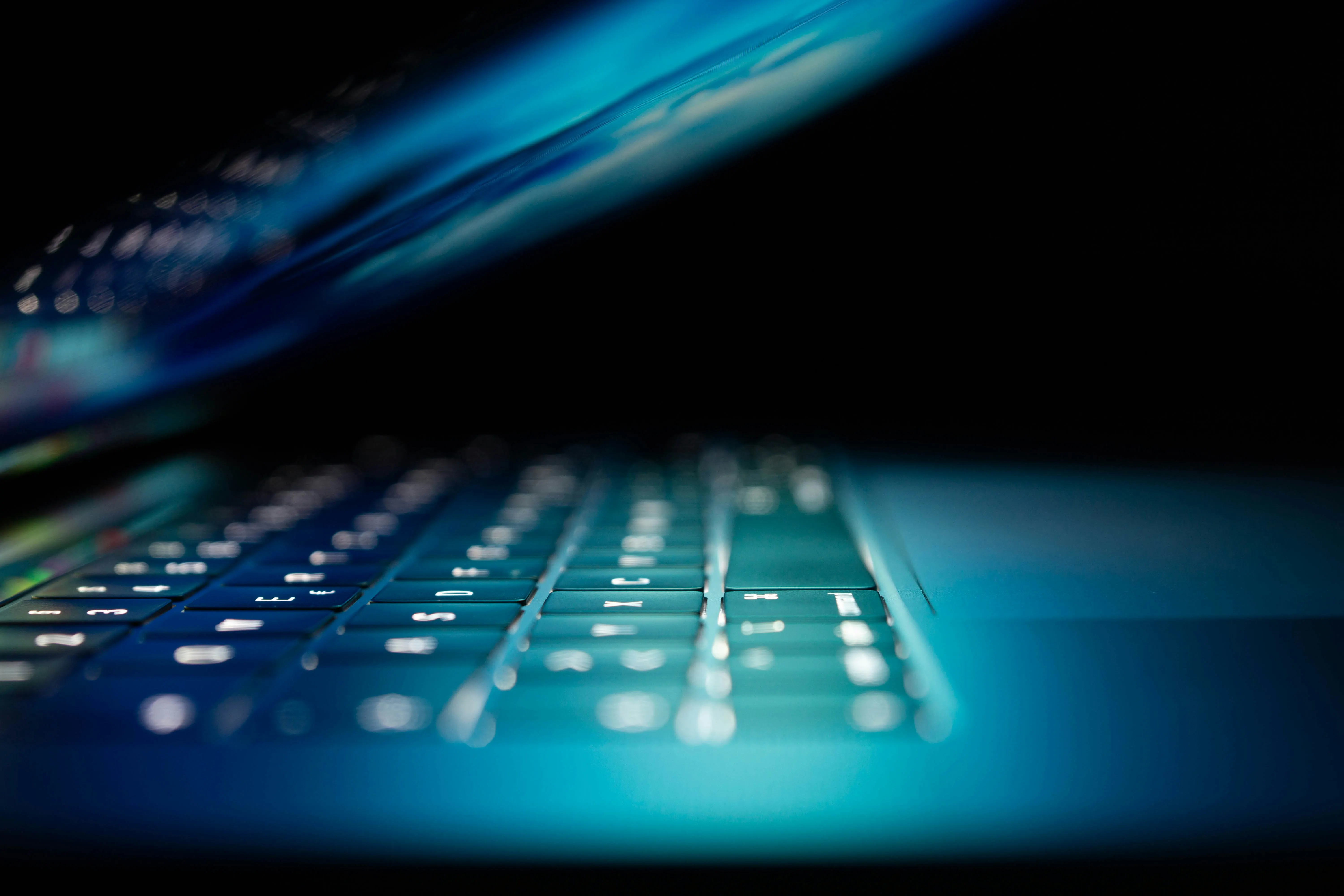 Teclado retroiluminado en azul con código en segundo plano